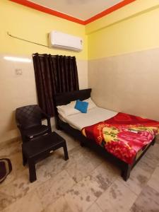 a small bedroom with a bed and a chair at Dstay in in Visakhapatnam