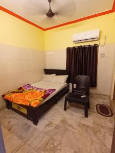 a bedroom with a bed and a chair at Dstay in in Visakhapatnam