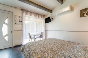 een slaapkamer met een bed, een raam en een tafel bij Studette Olivier in Les Taillades +13 foto's