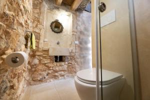 ein Badezimmer mit Toilette und Steinwand in der Unterkunft Villa Platino in Torre Vado + 30 Fotos