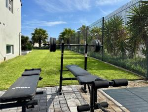 a gym with dumbbells and a bench in a yard at Boardrooms Kite Accommodation in Cape Town