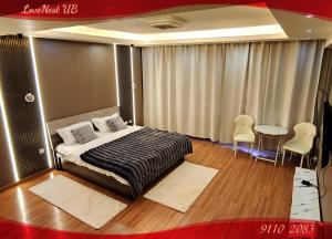 Un dormitorio con una cama y una mesa y sillas. en LoveNest UB, en Ulán Bator