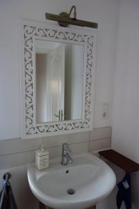 ein Badezimmer mit einem weißen Waschbecken und einem Spiegel in der Unterkunft Vive-Là übernachten mit Charme! in Kusterdingen + 17 Fotos