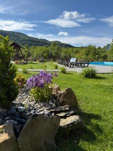 a garden with rocks and flowers in the grass at Bier House in Velyatyn