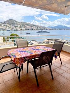 a table and chairs on a balcony with a view of the water at Sea View Apartment in Sarandë