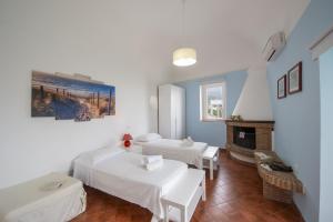 a room with two beds and a fireplace at Casa Punta Paradiso - Hot Tub and Panoramic Garden in Praiano