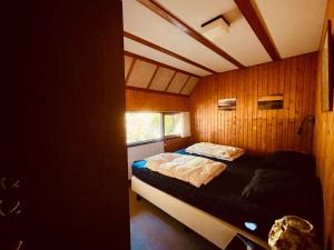 ein Schlafzimmer mit einem Bett in einem Zimmer mit Holzwänden in der Unterkunft De Vlier 9* in Nieuwvliet