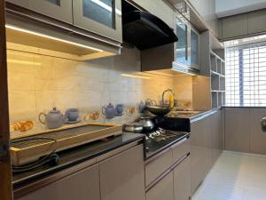 a kitchen with a stove and a counter top at City View Hotel & Apartment in Rājshāhi