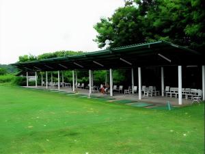a pavilion with tables and chairs in a park at Panorama Golf And Country Club in Ban Mai Samrong