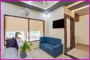 Una sala de estar con un sofá azul y un televisor. en Sea Facing Hotel The Dreamland Near Shree Jagannath Temple - Lift-Wifi-Parking and Restaurant Facilities - All Room Sea Facing With Attached Balcony -A luxuary Hotel in Puri, en Cuttack