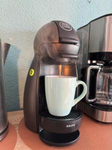 una macchinetta del caffè sta facendo una tazza di caffè di Evasion marine, appartement idéalement situé a Cap d'Agde
