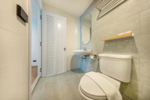 a bathroom with a white toilet and a sink at Ralph Poshtel Sukhumvit in Bangkok +112 photos