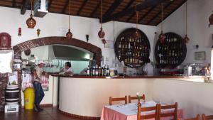 a woman standing at a counter in a restaurant at Casa Feliz in Odeceixe