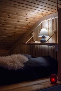 a bedroom with a bed with a lamp on it at Design Cabin with Jacuzzi, Sauna & Nature in Pertunmaa