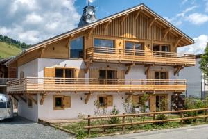 a house with a wrap around porch with a roof at Flocons de Sel - Relais & Chateaux in Megève
