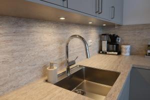 a kitchen with a sink and a counter top at Hamn i Senja - Private top apartment with seaview in Senja