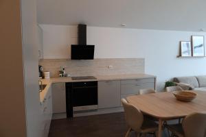 a kitchen with a table and a dining room at Hamn i Senja - Private top apartment with seaview in Senja