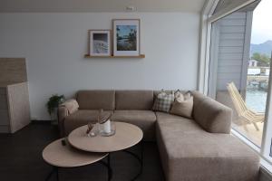 a living room with a couch and two tables at Hamn i Senja - Private top apartment with seaview in Senja +26 photos