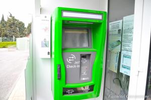 une machine à atm vert sur le côté d'un bâtiment dans l'établissement Fasthotel Carcassonne, à Carcassonne