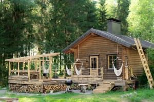 a log cabin with a porch and a deck at Design Cabin with Jacuzzi, Sauna & Nature in Pertunmaa +20 photos