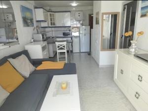 a living room with a couch and a kitchen at New Puerto Rico Bonanza in Mogán