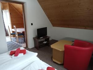 a bedroom with a bed and a desk and a chair at Nefelejcs Apartman in Fertőhomok