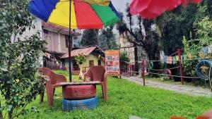 a table with an umbrella and chairs on top of a barrel at Hotel Eco-Nest - Best Stay near Bhagsu Waterfall in McLeod Ganj