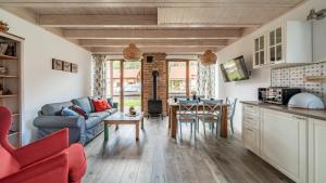 a kitchen and living room with a couch and a table at Ostoja Bukowo, Sun & Snow in Borowy Młyn