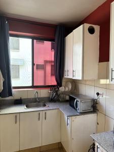 a small kitchen with a sink and a window at Pumzika Town House in Arusha