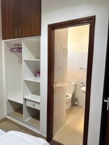 a small bathroom with a toilet and a glass door at Pumzika Town House in Arusha