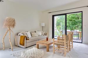 a living room with a couch and a table at Casa Sitha magnifique maison de vacances de 110m2 à proximité des plages in Gouville-sur-Mer