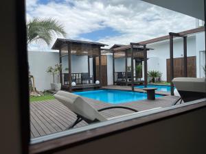 a house with a swimming pool and a deck with chairs at Onomichi Villa Ayah in Onomichi