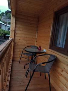 a small table and chairs on the porch of a cabin at Hotel Zghapari in Aspindza +7 photos
