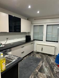 a kitchen with white cabinets and black counter tops at Schönes wohnen in Vienna