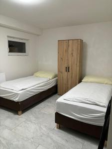 two twin beds in a room with a cabinet at Schönes wohnen in Vienna
