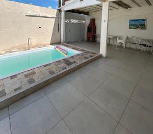 a swimming pool on a patio with a table and chairs at Casa na Ilha de Itamaraca in Vila Velha