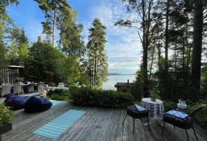 una terraza con sillas y una mesa y vistas al agua en Cozy and spacious vacation house by the sea, en Kemiönsaari