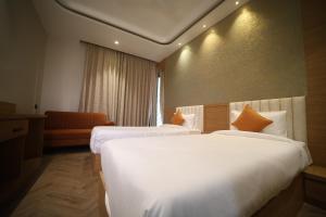 a hotel room with two beds and a couch at Elight Inn Hotel in Jaipur +40 photos