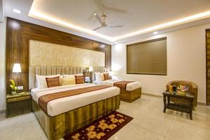 a hotel room with two beds and a table at Hotel The Prithvi Near Delhi Airport in New Delhi +127 photos
