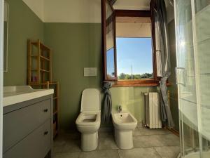 a bathroom with a toilet and a sink and a window at B&C Garda House in Peschiera del Garda