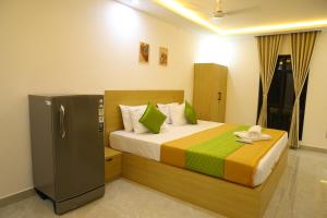 a bedroom with a bed and a refrigerator in it at Aeroview Homestay Near Chennai Airport and Rela Hospital in Chennai