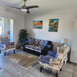 a living room with a couch and two chairs at Dolfyn201 La Mer in Hartenbos