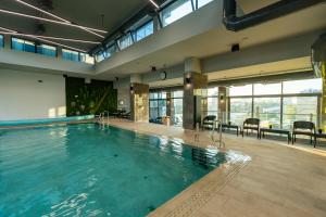 - une grande piscine dans une grande pièce dotée de fenêtres dans l'établissement East Plaza Hotel, à Sofia