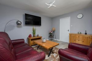 a living room with two red couches and a table at House -Sleeps 8 parking suitable for contractors in Ecclesfield