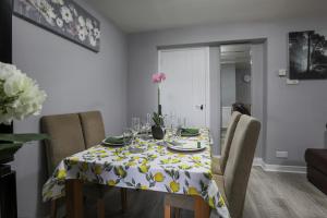 a dining room table with a table cloth with yellow flowers at House -Sleeps 8 parking suitable for contractors in Ecclesfield +13 photos