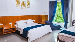 a bedroom with two beds and a window at Villa Sapphire by Blue Robin - Private Taiping Villa 20pax River & Waterfall in Taiping