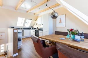 una cucina e una sala da pranzo con tavolo e sedie in legno di Sommerfrische a Ahrenshoop