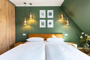 una camera da letto con un letto bianco con pareti verdi di Sommerfrische a Ahrenshoop