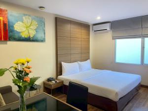 a hotel room with a bed and a vase of flowers at AMIS By Sima Thani in Ban Lak Roi