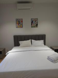 Una gran cama blanca con dos cuadros en la pared. en Quill Residence KL Suites, en Kuala Lumpur 23 fotos más